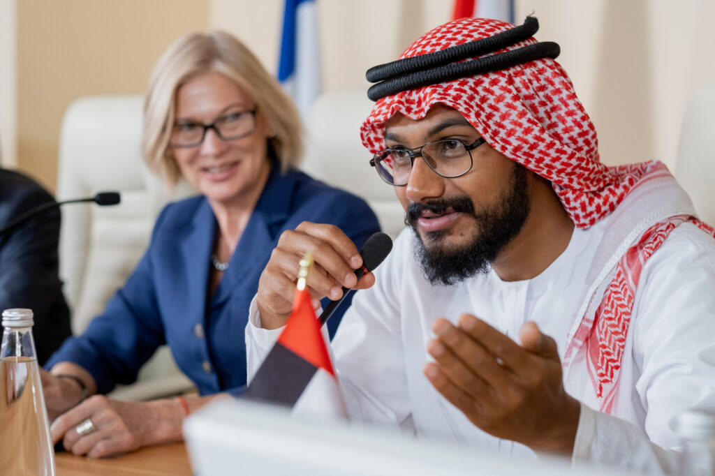 bearded delegate in turban and eyeglasses making report